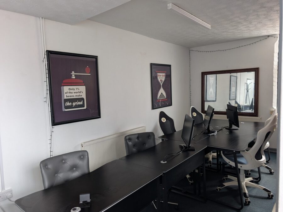 Shared desks with monitors under framed coffee posters
