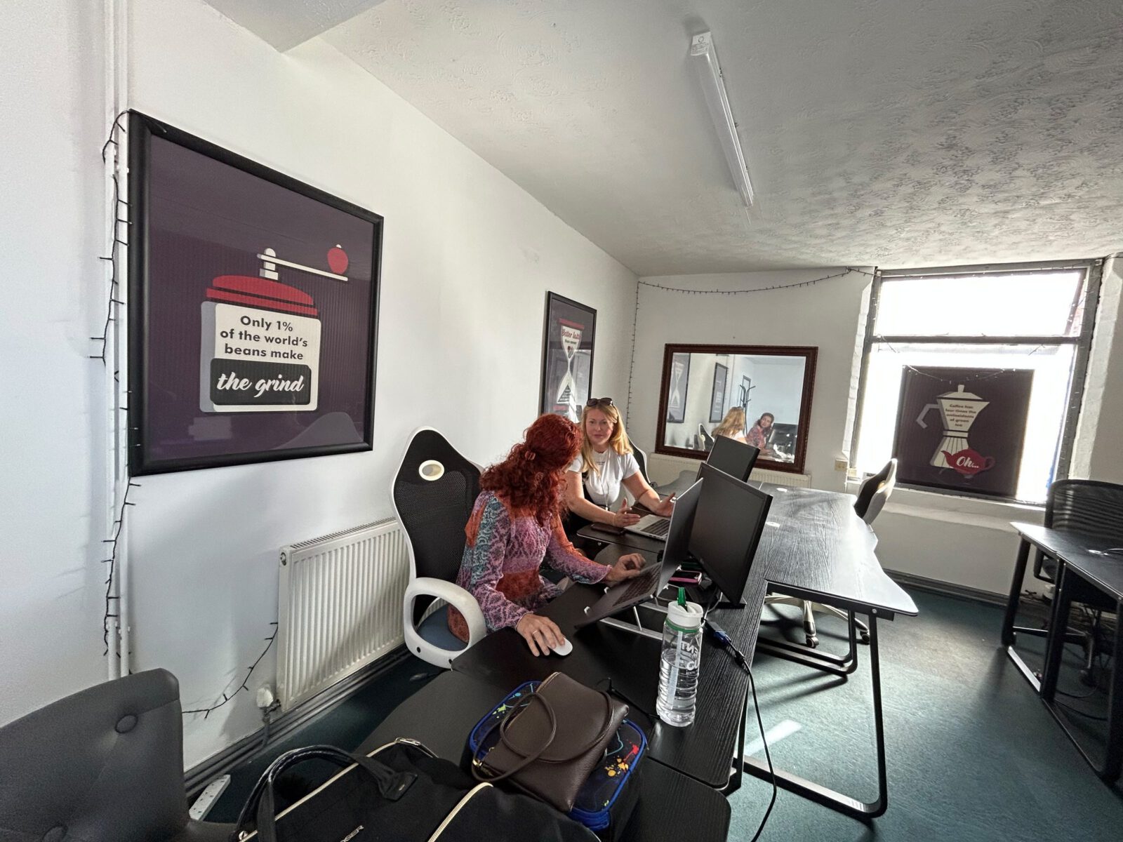 A wide view of the coworking room with members working at the desks