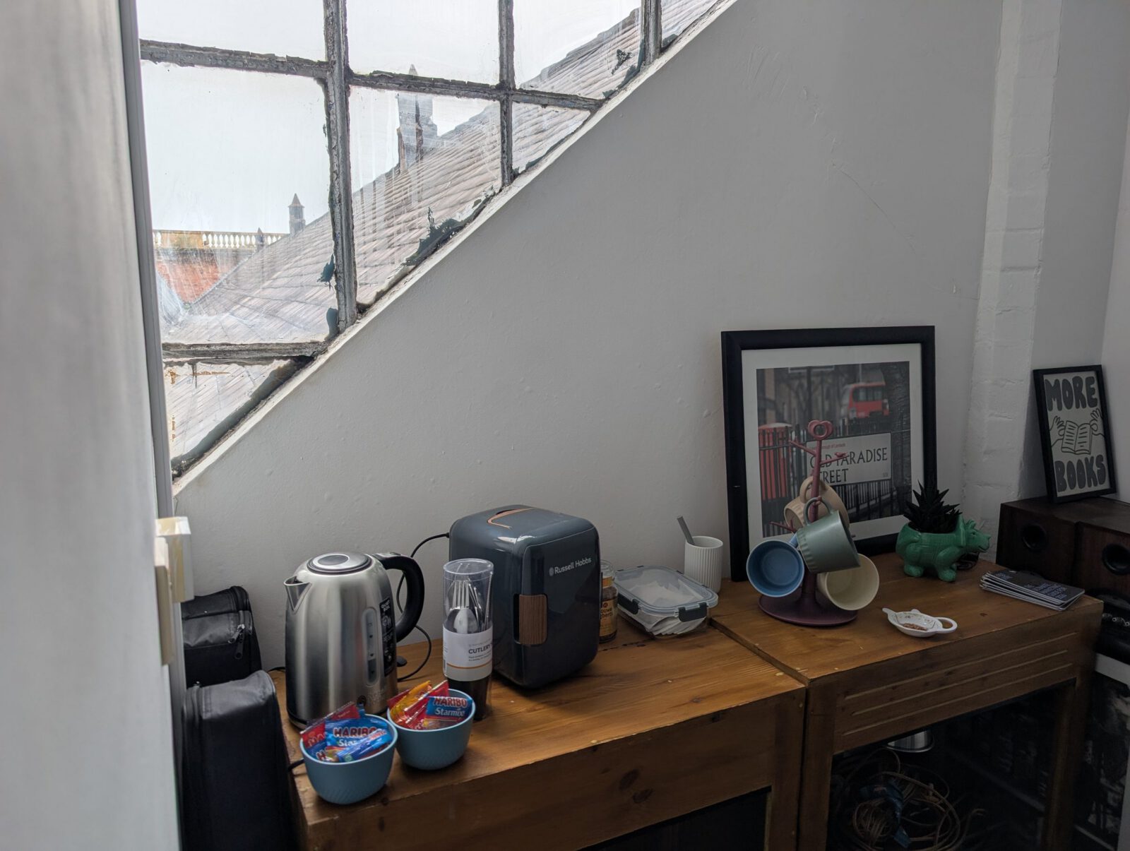 The tea and coffee station with a kettle, coffee machine and mugs by the window